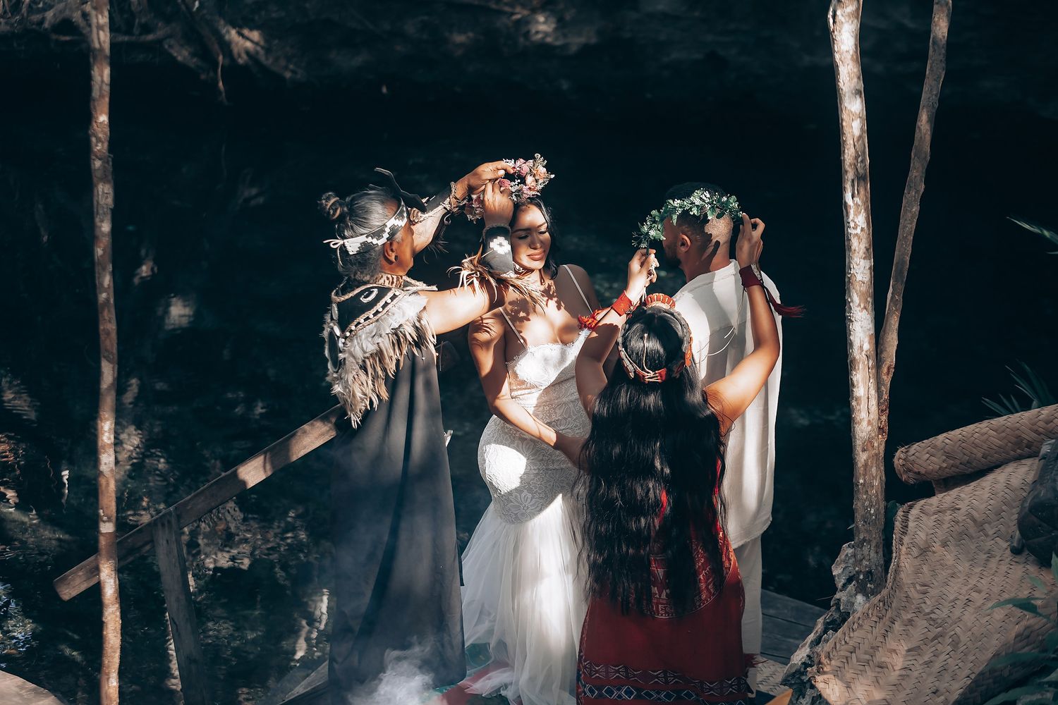 A couple shares an intimate dance moment surrounded by trees and guests at an outdoor wedding celebration.