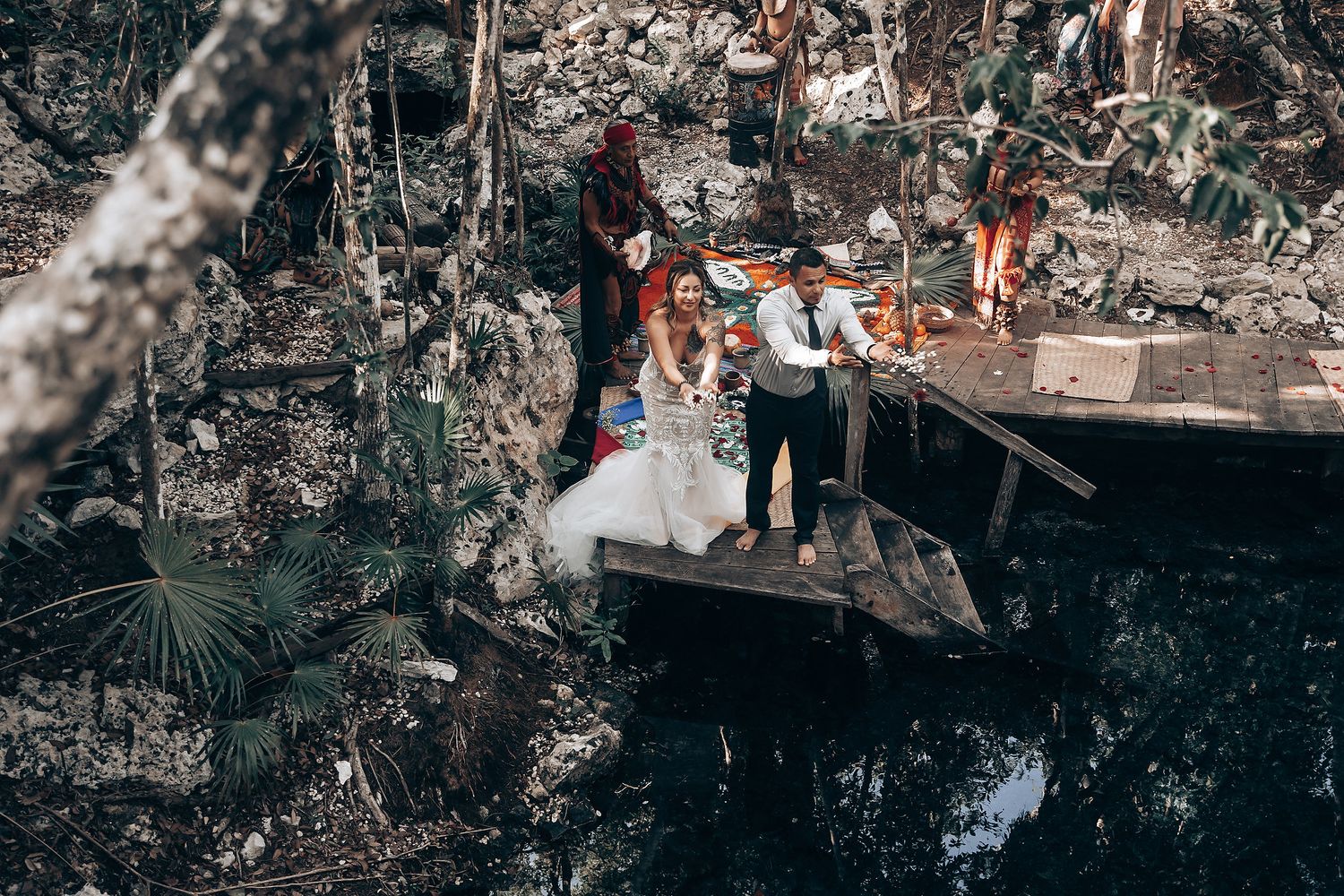 An intimate wedding celebration unfolds in a dramatic underground cave with natural rock formations.