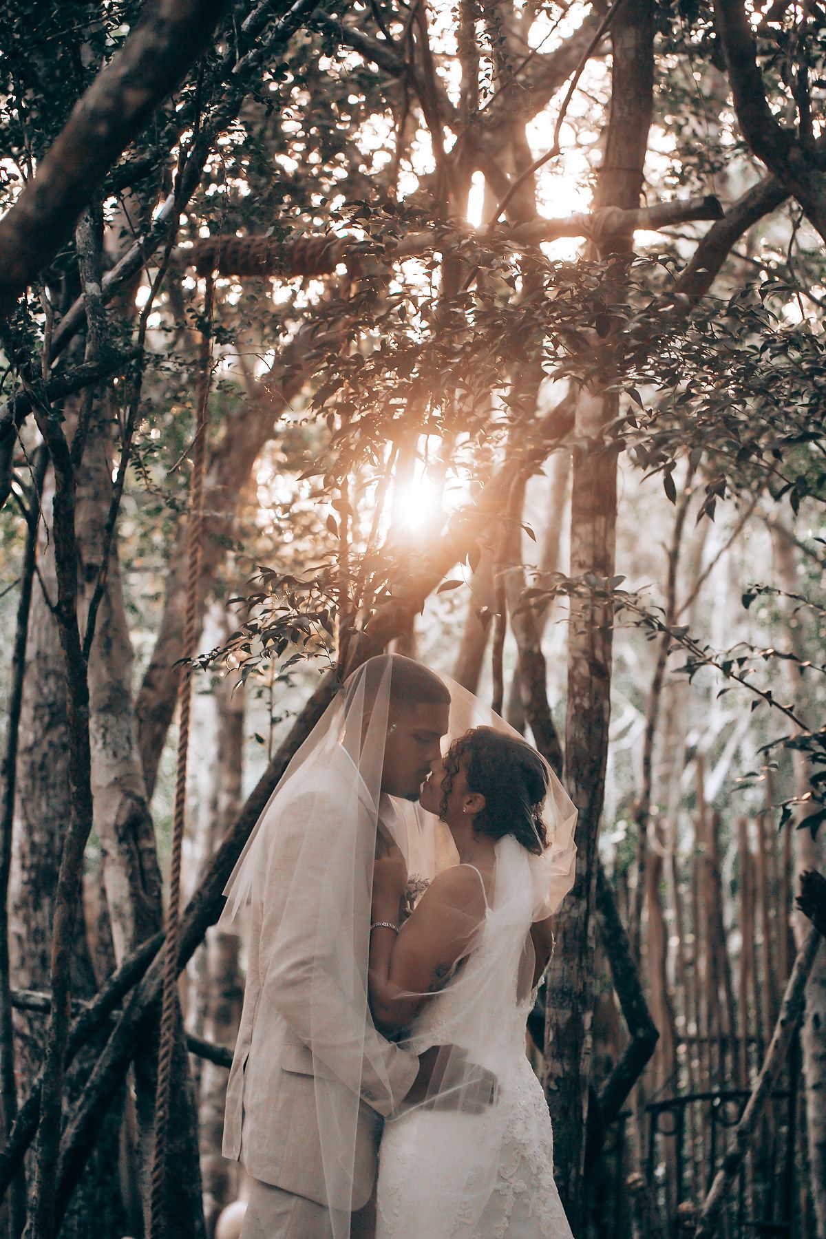 Golden sunlight filters through trees during an intimate wedding photoshoot.