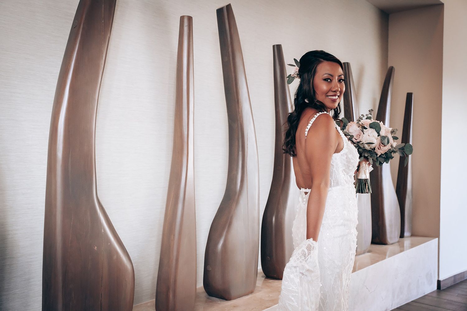 Elegant bridal gown displayed in a modern dressing room with soft natural lighting.