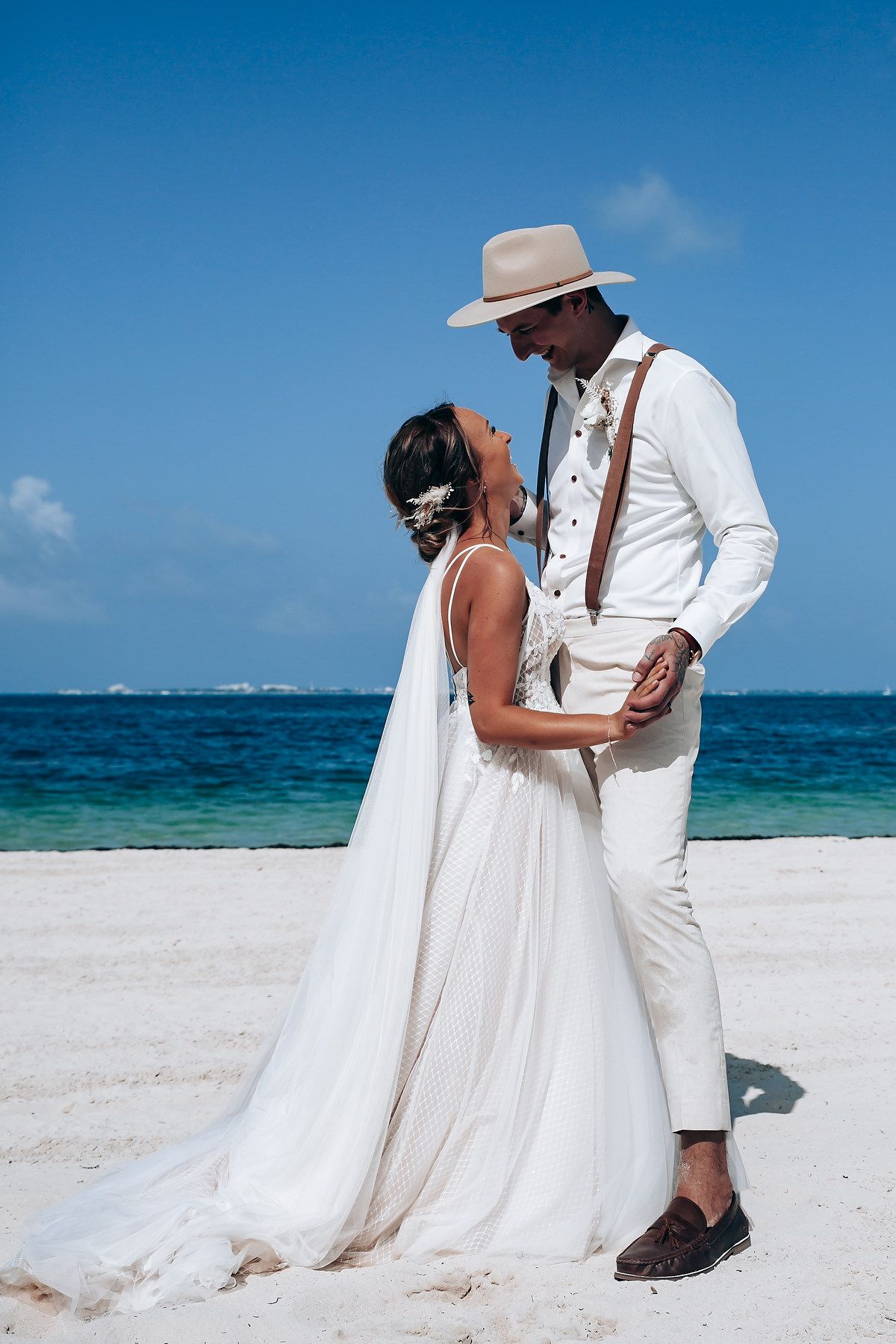 Intimate wedding couple moments captured along a pristine beach with crystal blue waters.