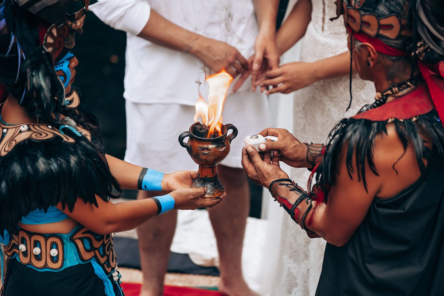 Close-up of hands lighting a ceremonial candle during a traditional celebration event.