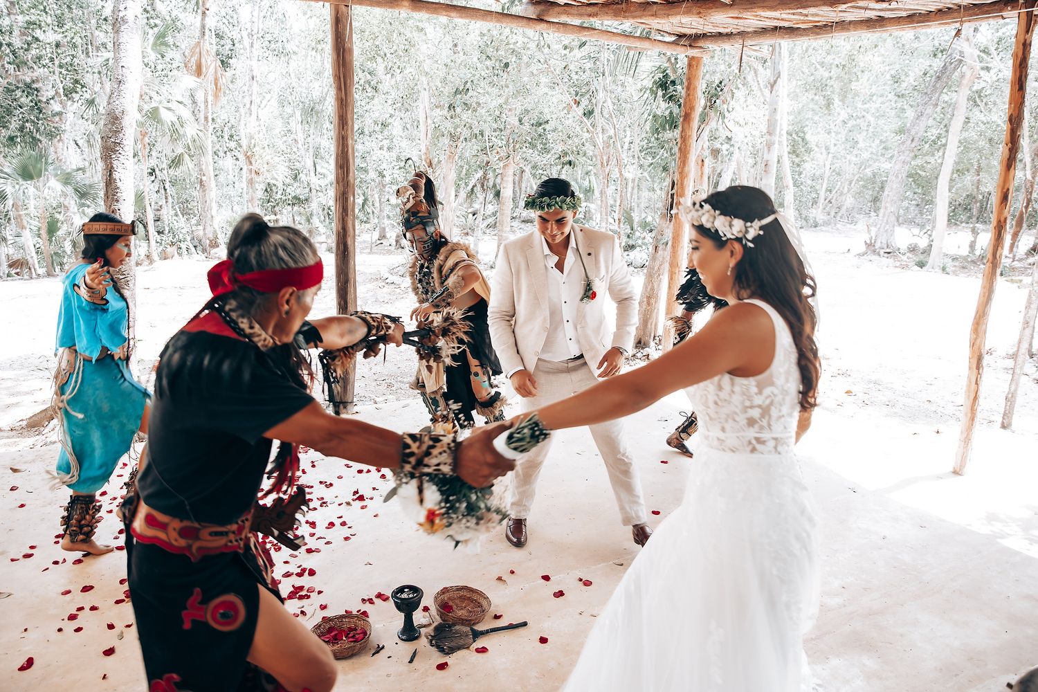 Wedding guests gathered under a canopy in a natural forest setting.