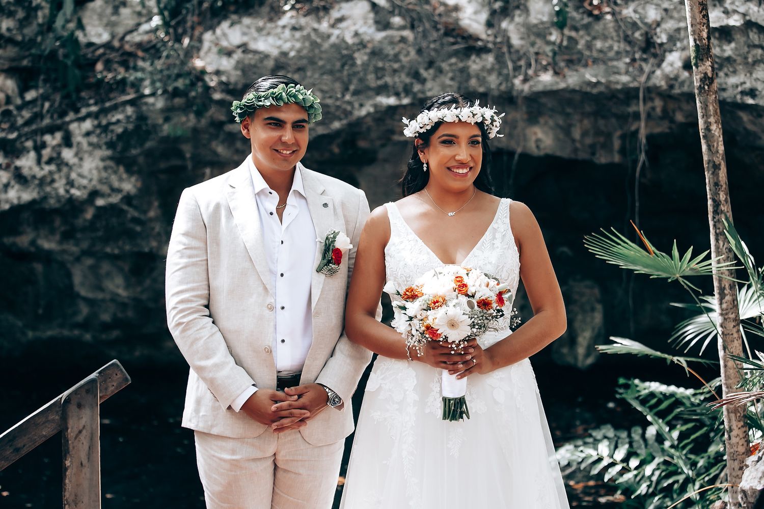 Couple celebrates their wedding ceremony on a wooden platform surrounded by tropical forest.