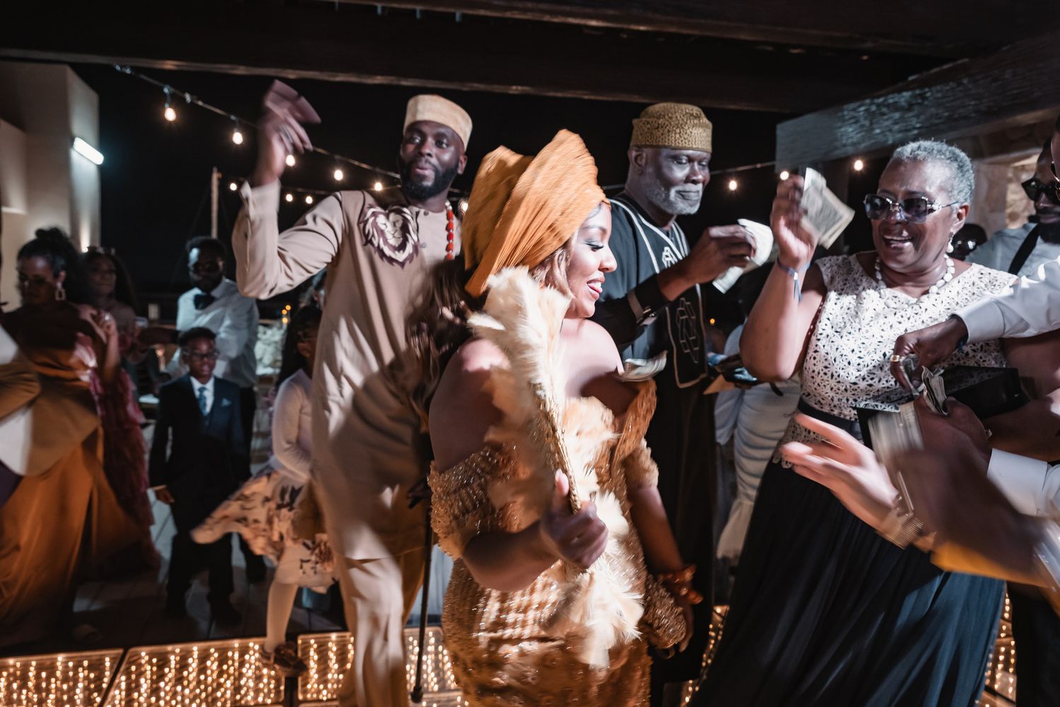 Joyful African traditional wedding celebration with guests dancing in cultural attire.