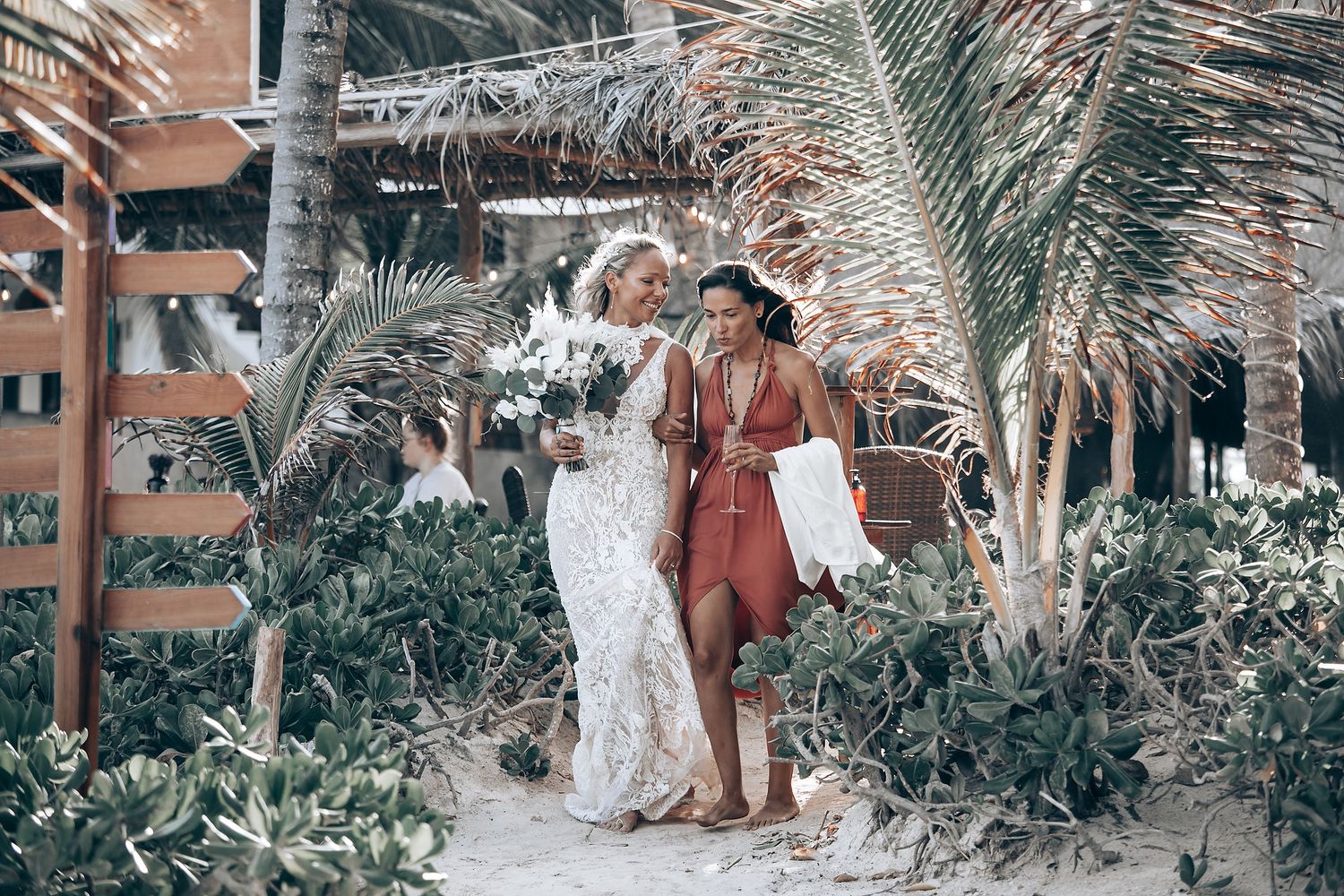 Beachfront wedding ceremony with tropical foliage and ocean views.
