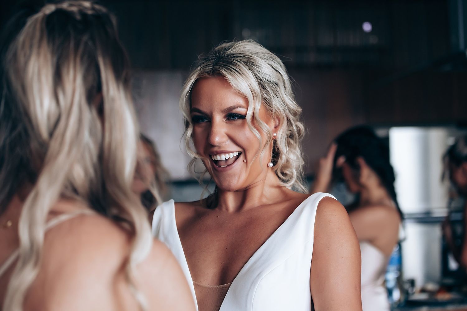 A candid moment of joy and laughter shared between friends getting ready in formal attire.