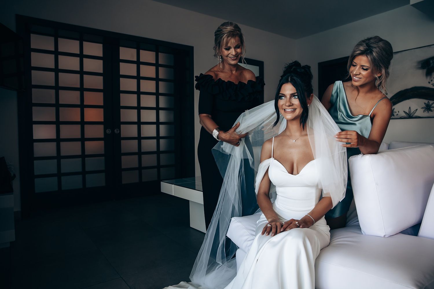Wedding preparations in a modern room with elegant white decor and natural lighting.
