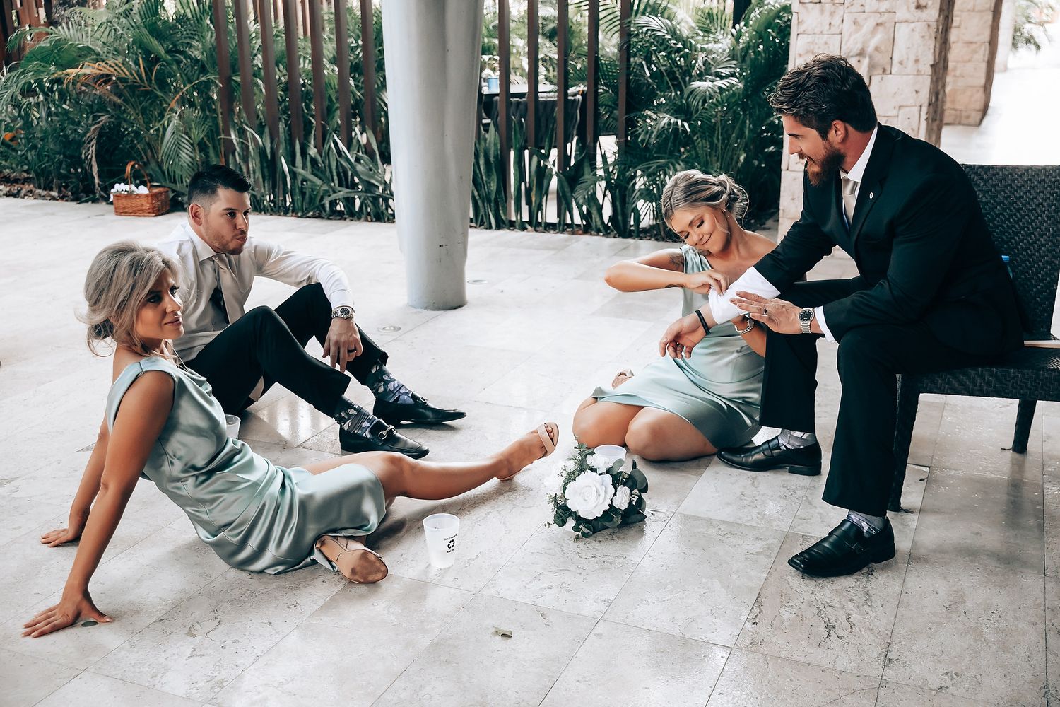 Wedding guests participate in a synchronized dance routine on an outdoor patio during a reception celebration.