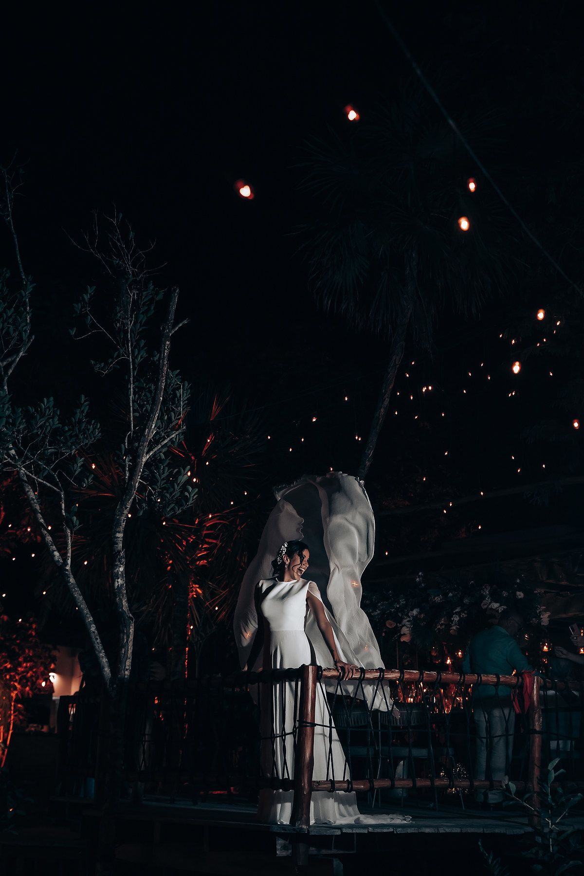 Romantic nighttime wedding scene with string lights illuminating the outdoor venue.