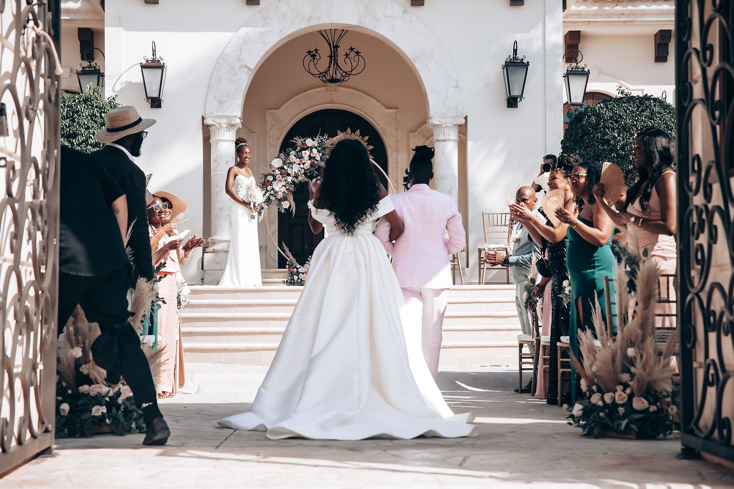 Wedding celebration at an elegant Mediterranean-style venue with white columns and arches.