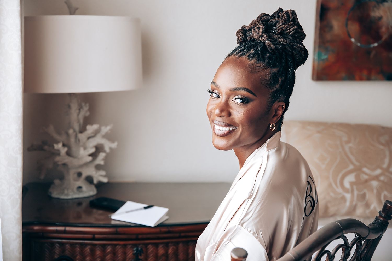 A candid morning preparation moment showing a white robe and elegant updo hairstyle.