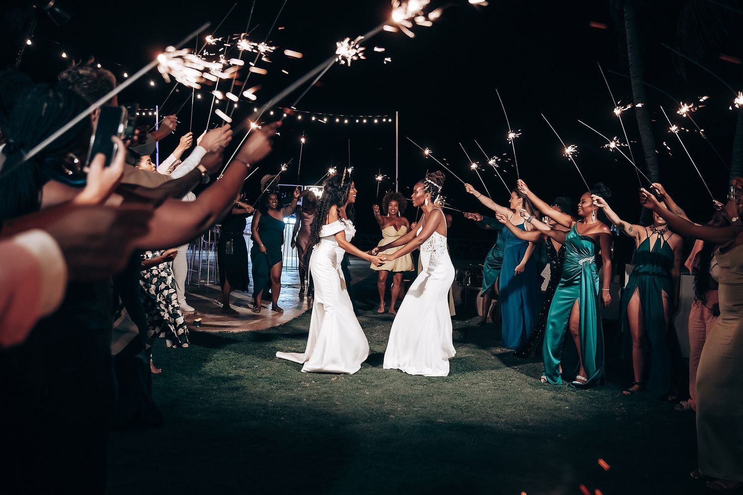 Wedding sparkler exit with guests creating a tunnel of lights in the evening.