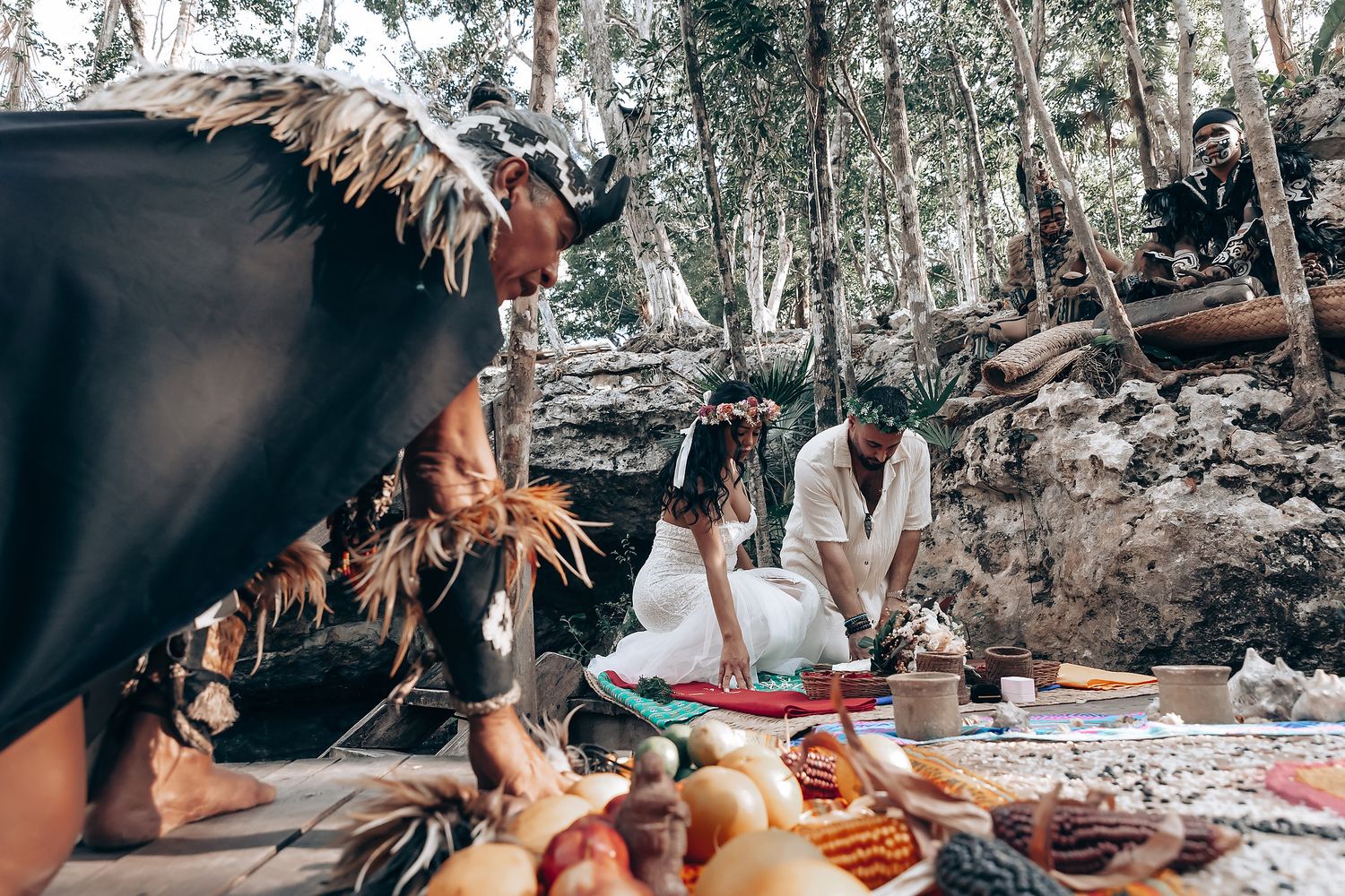Wedding celebration setup in a forest clearing with food and decorations.