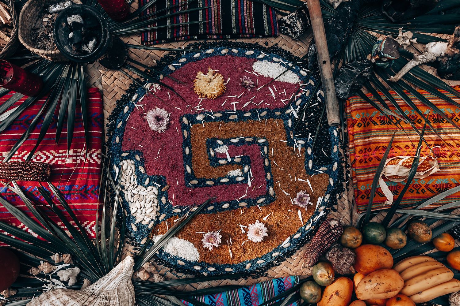 Colorful bohemian picnic setup with rugs, pillows, and traditional decorations in warm tones.