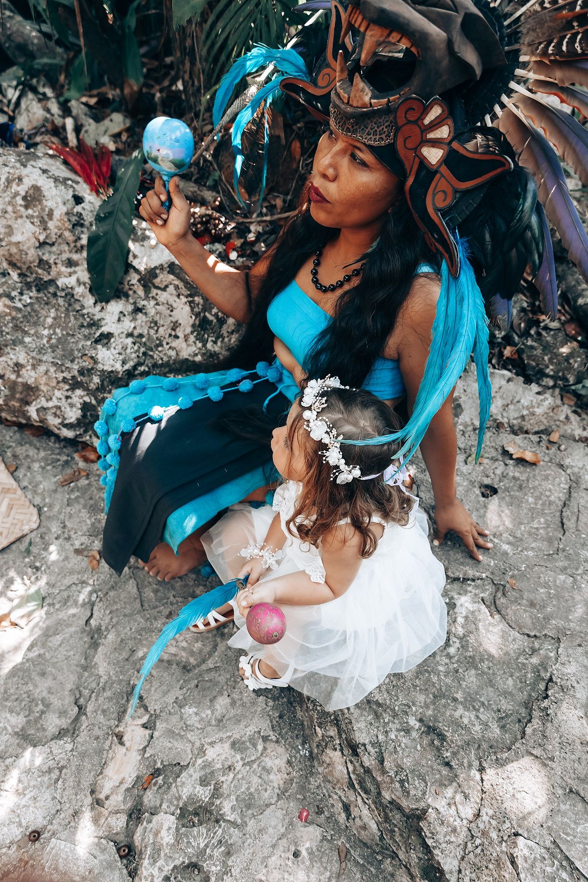 Traditional ceremony participants wearing turquoise and white attire on ancient stone steps.