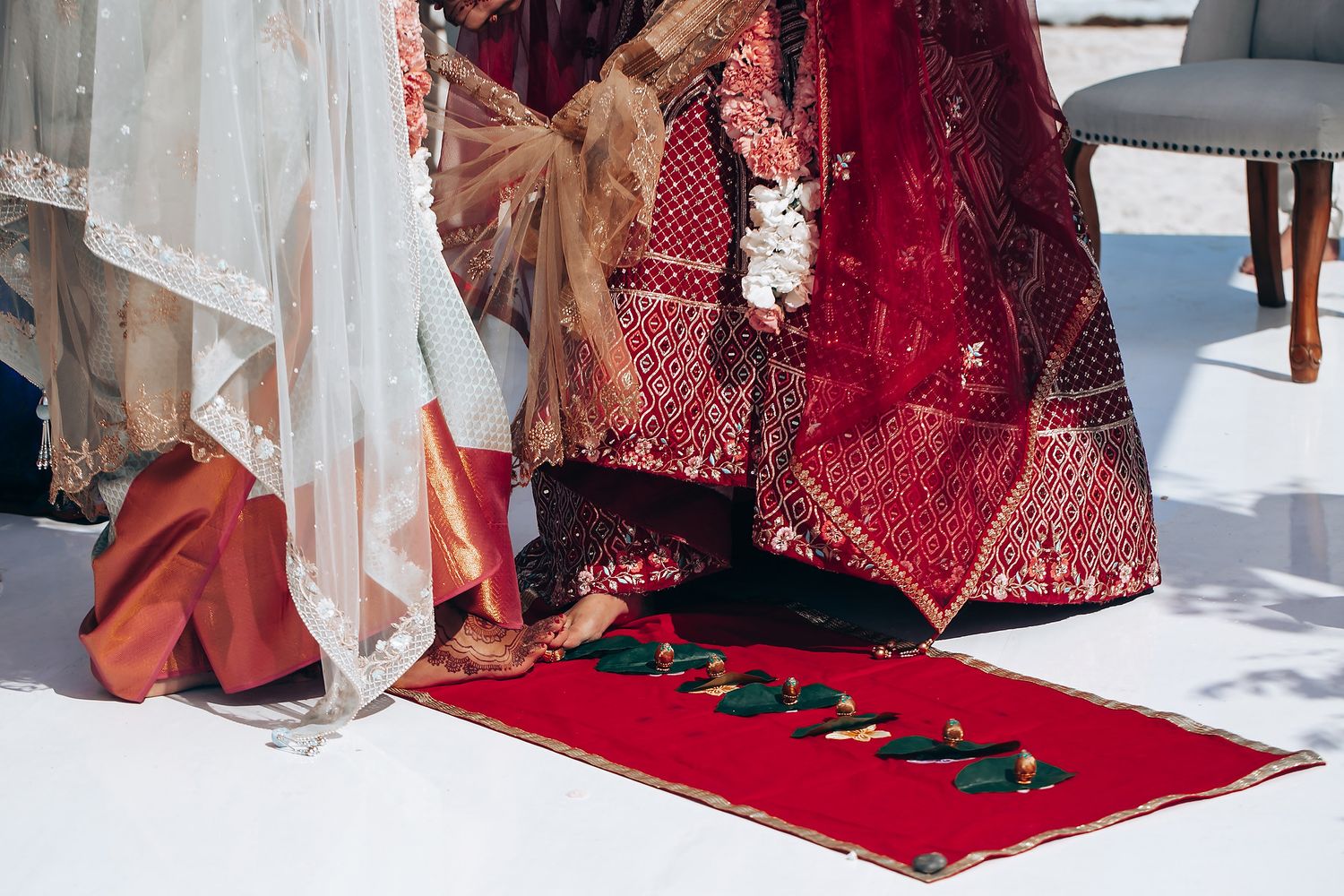 Traditional Indian wedding ceremony with participants seated on floor cushions.
