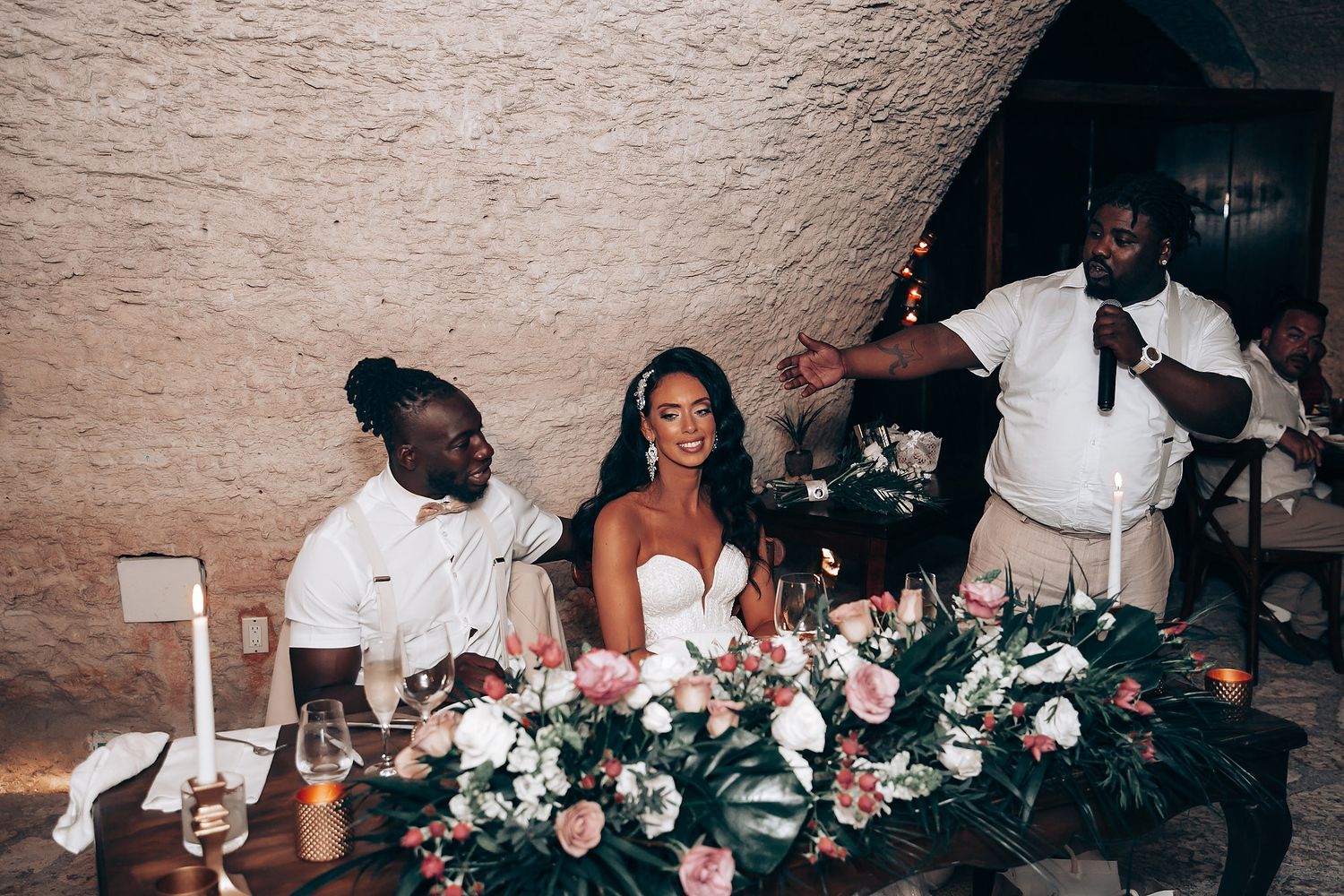 Wedding guests enjoying a festive celebration in a rustic cave venue.