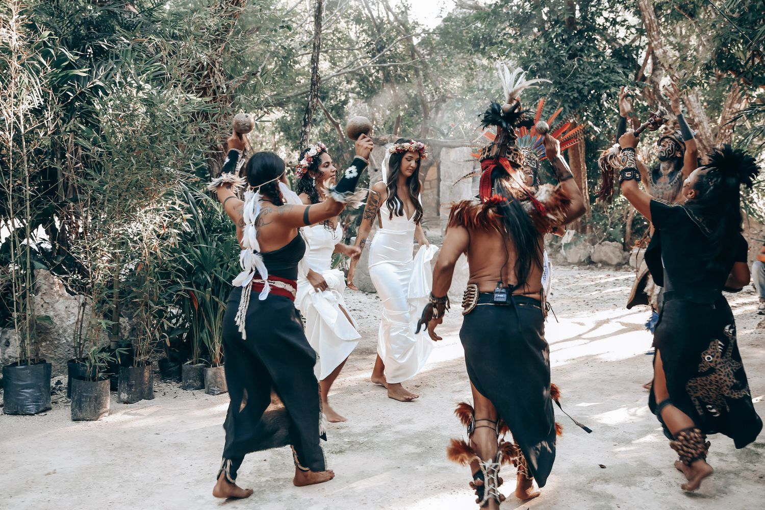 A group gathers outdoors for a nature-based ceremony among trees and natural surroundings.
