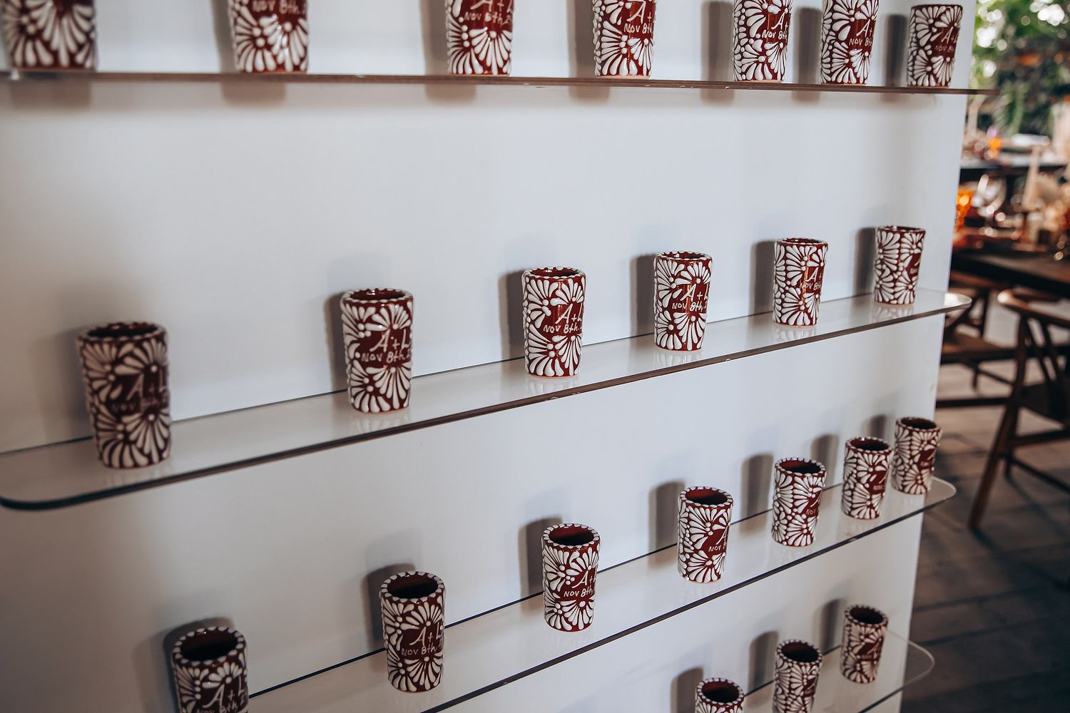 Rows of identical red and white patterned disposable coffee cups arranged on floating wall shelves.