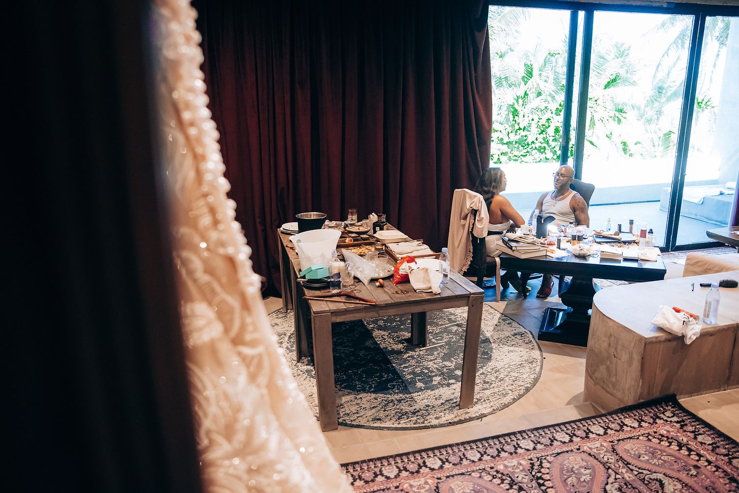 Modern wedding reception venue setup with elegant decor and large windows overlooking natural scenery.