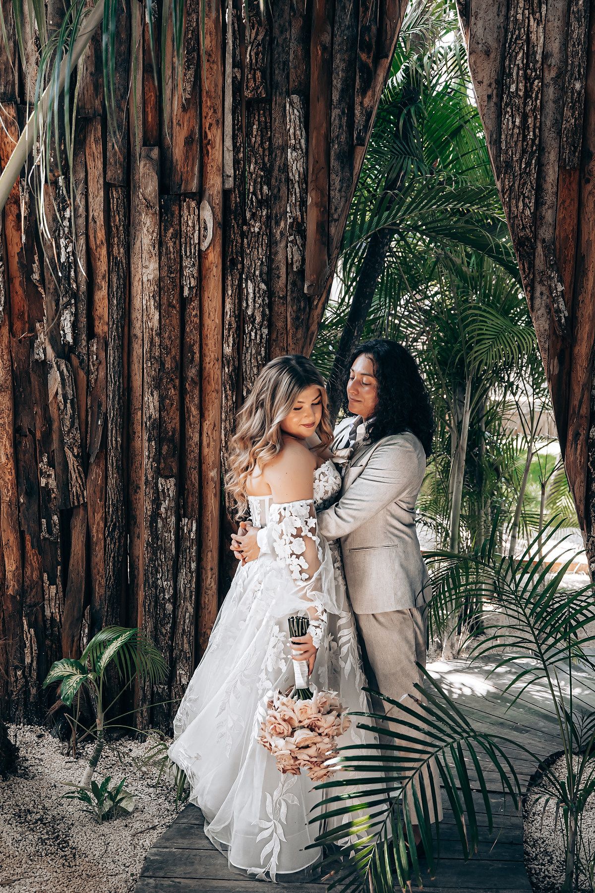 Wedding couple portraits among rustic wooden walls and tropical palm fronds.