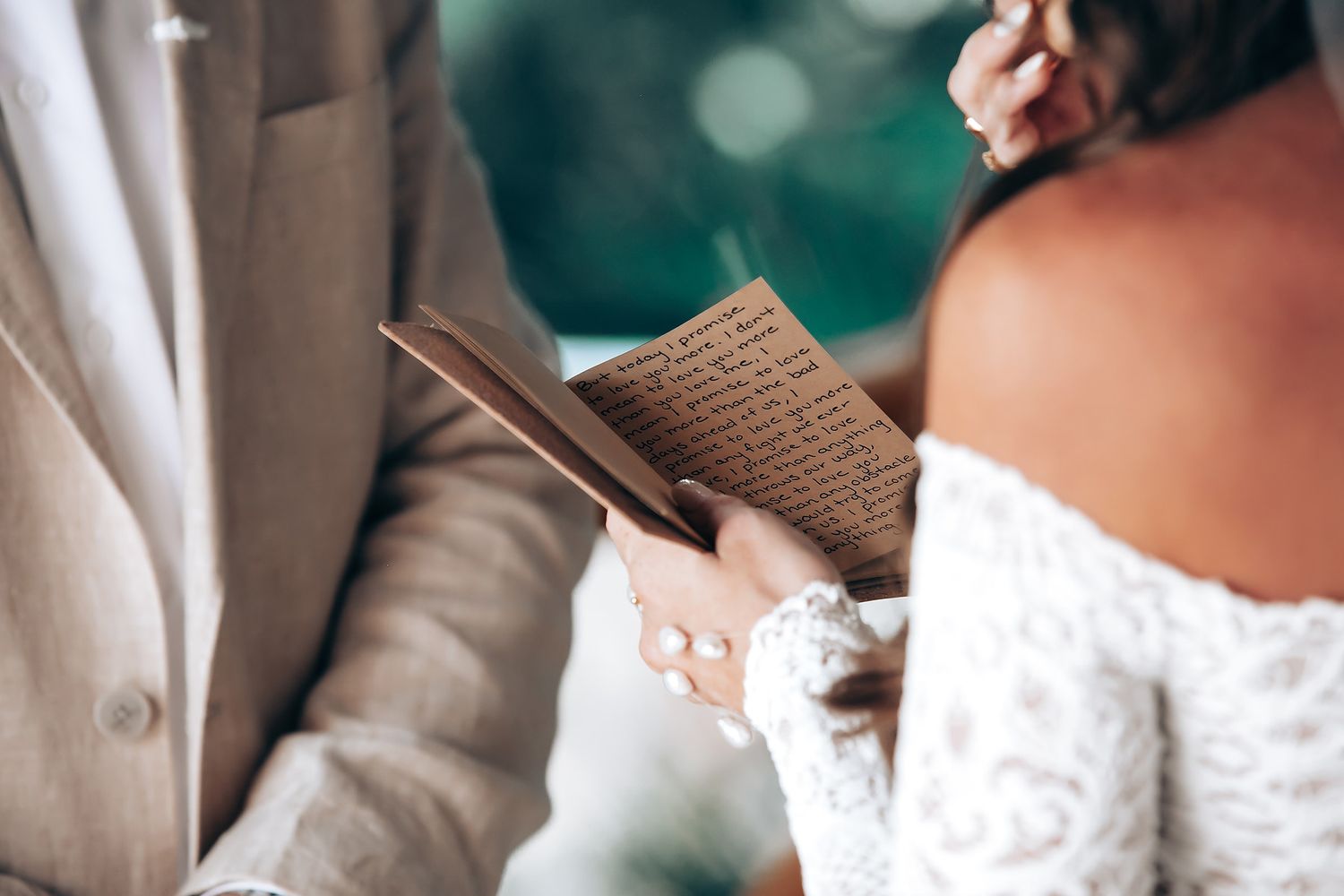 Delicate lace details of a white wedding dress captured in soft light.