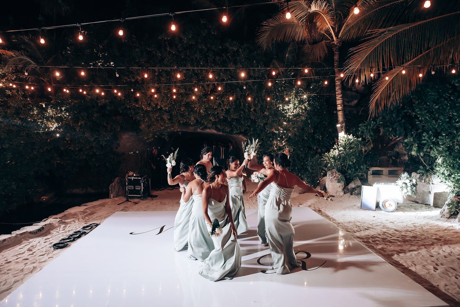 Evening wedding reception with string lights creating a magical ambiance over the dance floor.