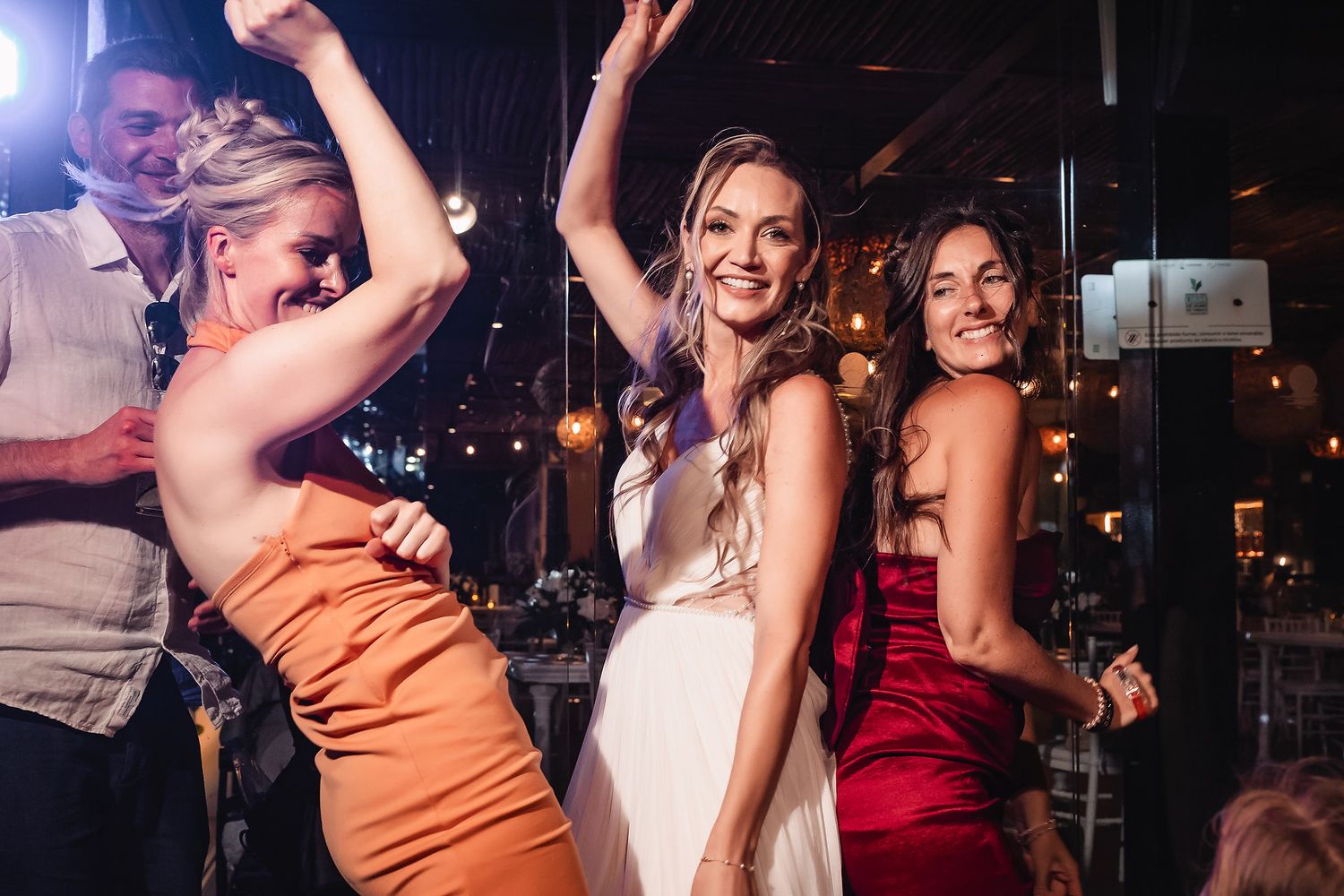 Dancers in colorful attire moving energetically under nightclub lighting.
