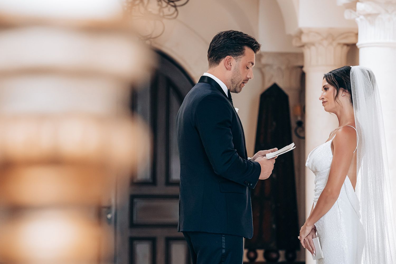 A romantic wedding couple shares tender moments in an elegant venue during their special day.