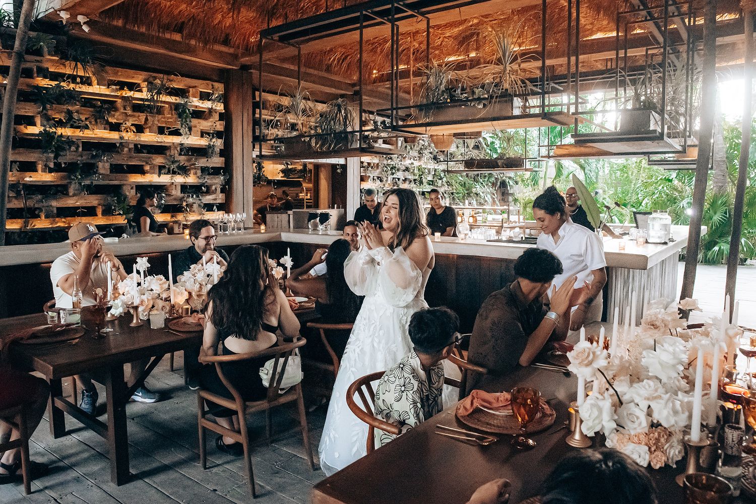 Wedding reception venue with rustic wooden ceiling and warm ambient lighting.