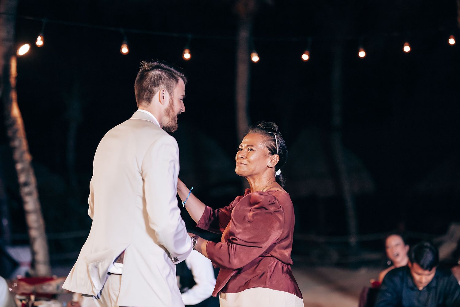 Evening wedding reception with string lights creating a warm ambiance.