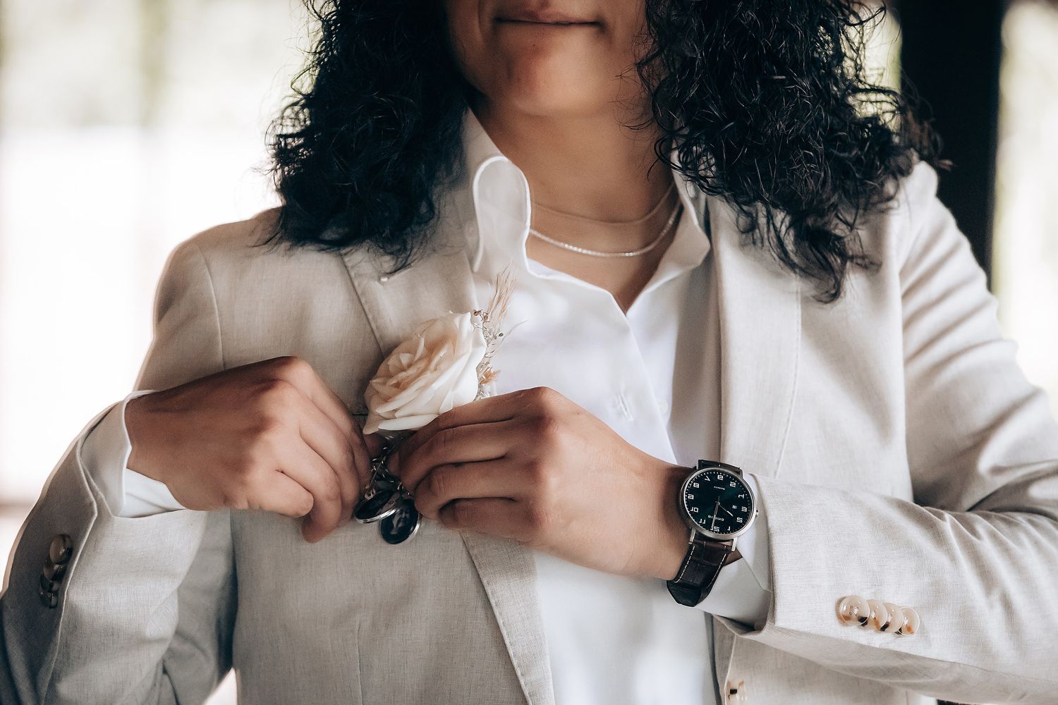 Person in white button-up shirt smiling during intimate portrait session.