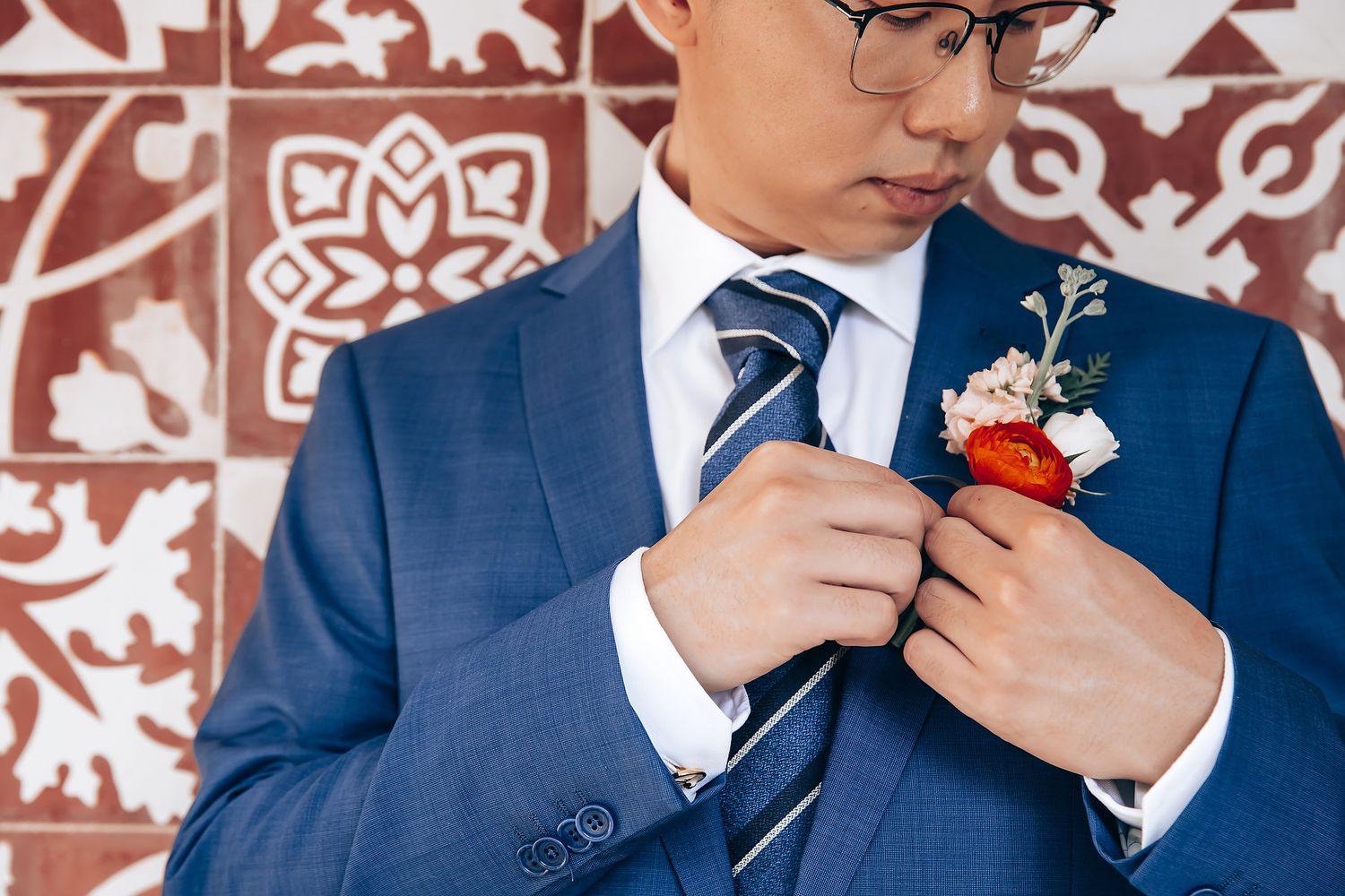 Close-up details of formal attire with traditional Chinese decor in the background.