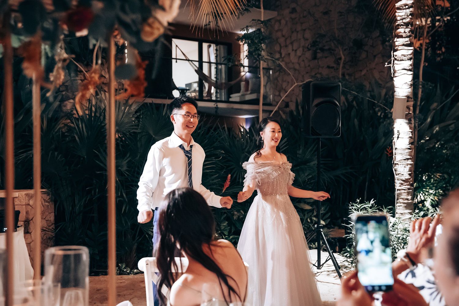 Wedding reception dance floor with romantic lighting and birch tree decor.
