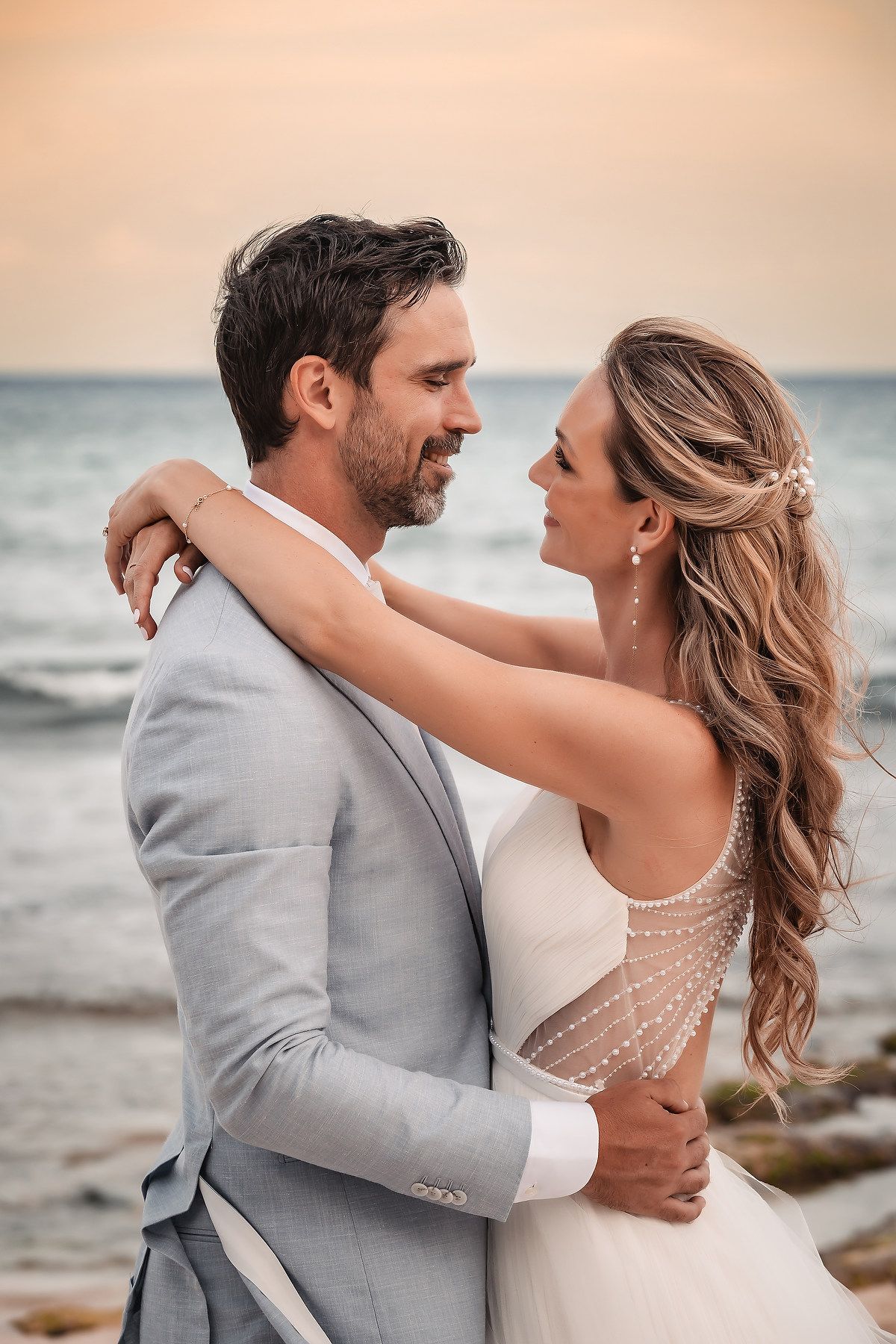 Romantic beach wedding portraits with couple dancing by the ocean.