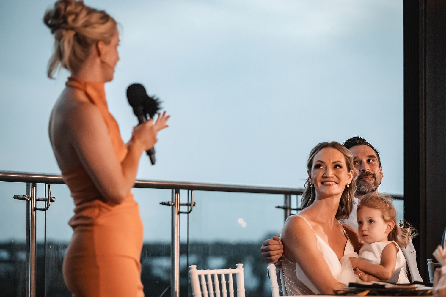Wedding reception moment captured on elegant rooftop venue overlooking cityscape.