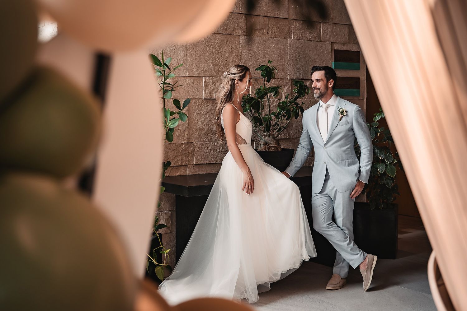 A couple shares an intimate moment in a beautifully lit indoor space.