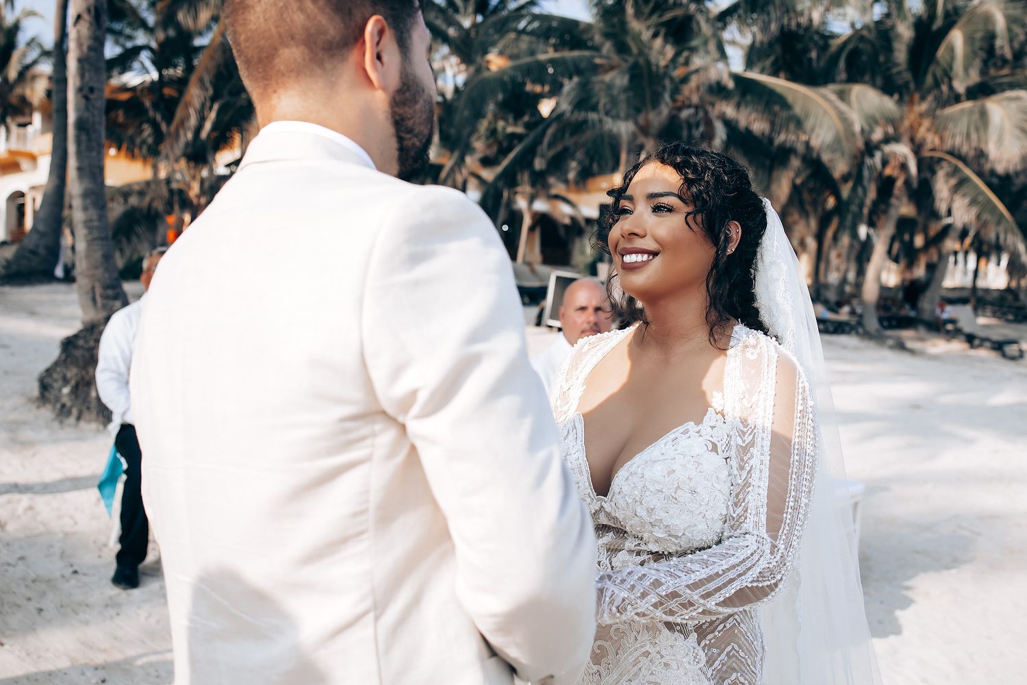 A happy couple shares joyful moments on their wedding day outdoors in a sunlit garden setting.