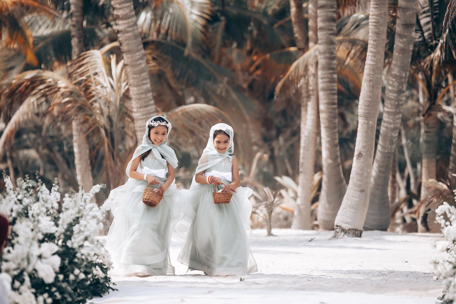 Traditional Sikh wedding ceremony setup with white decor and palm trees on a beach.