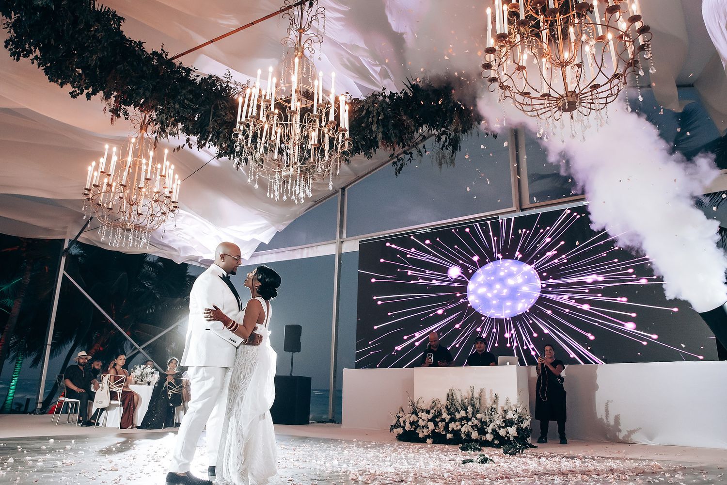 Elegant wedding reception venue with crystal chandeliers and decorative lighting creating a romantic atmosphere.