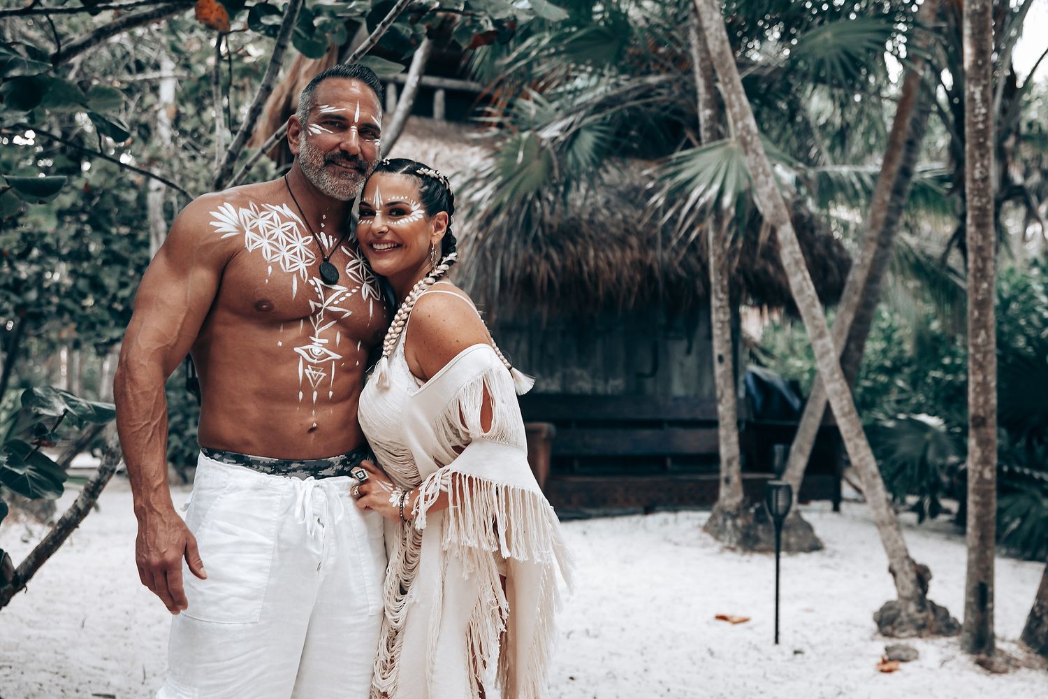 An intimate beach wedding photo session with white clothing and artistic body paint.