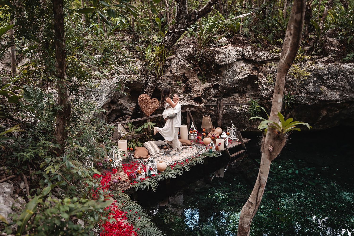 Scenic cenote platform decorated with red flowers and rustic elements.