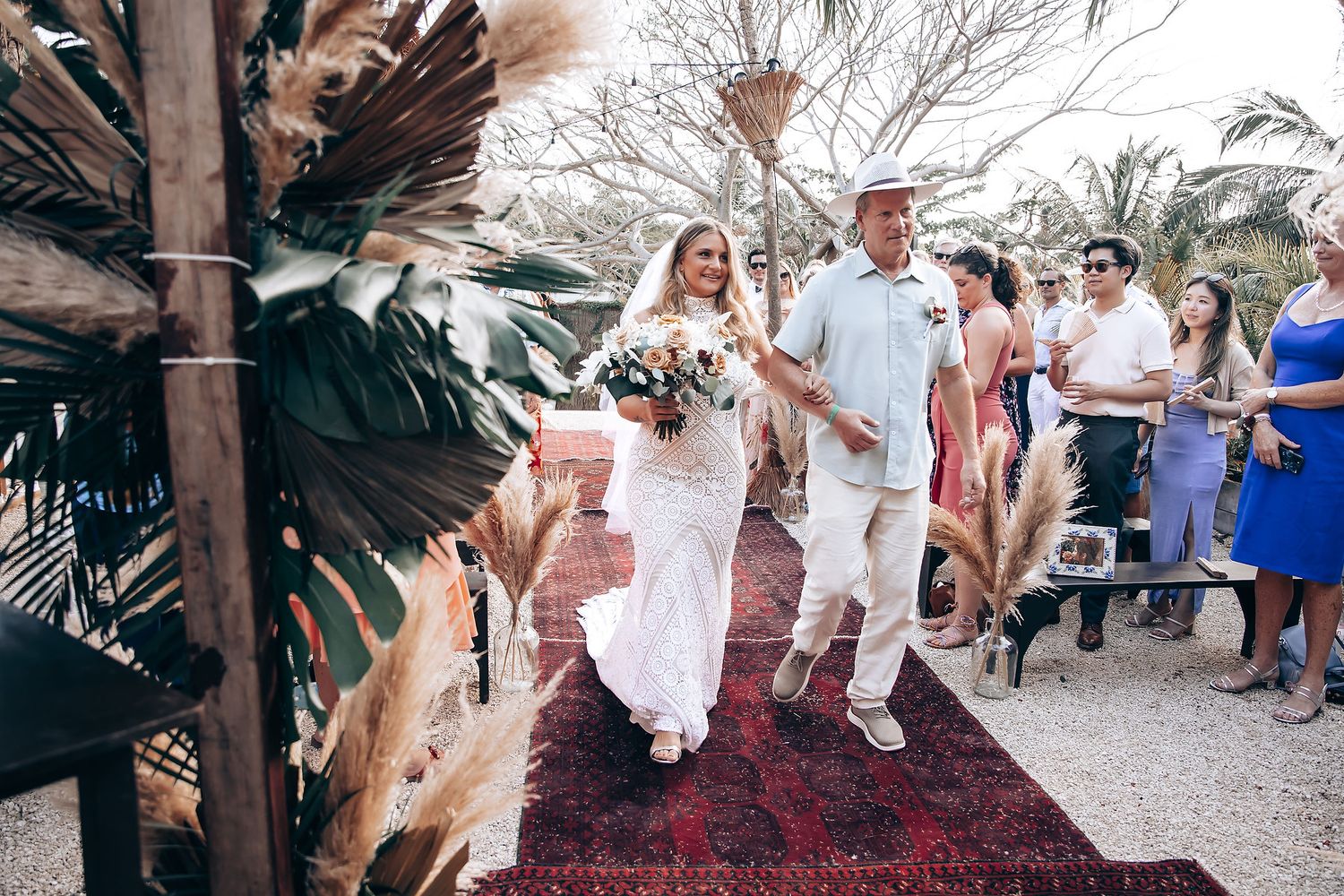 Wedding guests celebrating and dancing at an outdoor tropical reception.