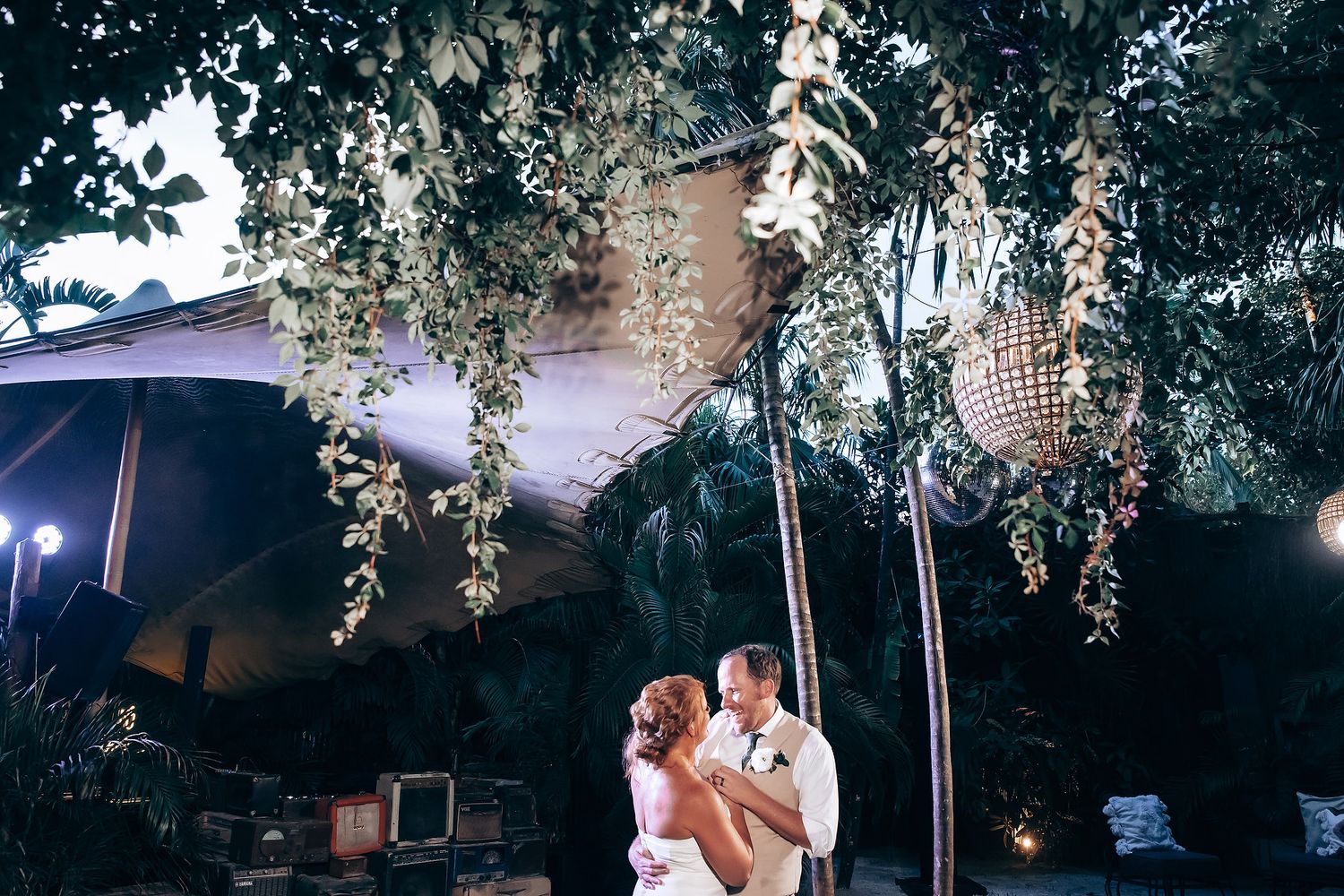 Evening outdoor reception under string lights and tree canopy.