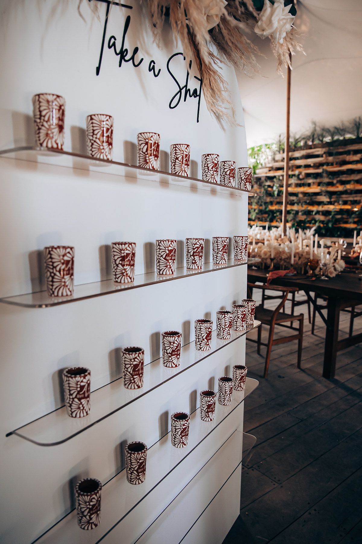 White wall display with decorative votives arranged on floating shelves in an event space.