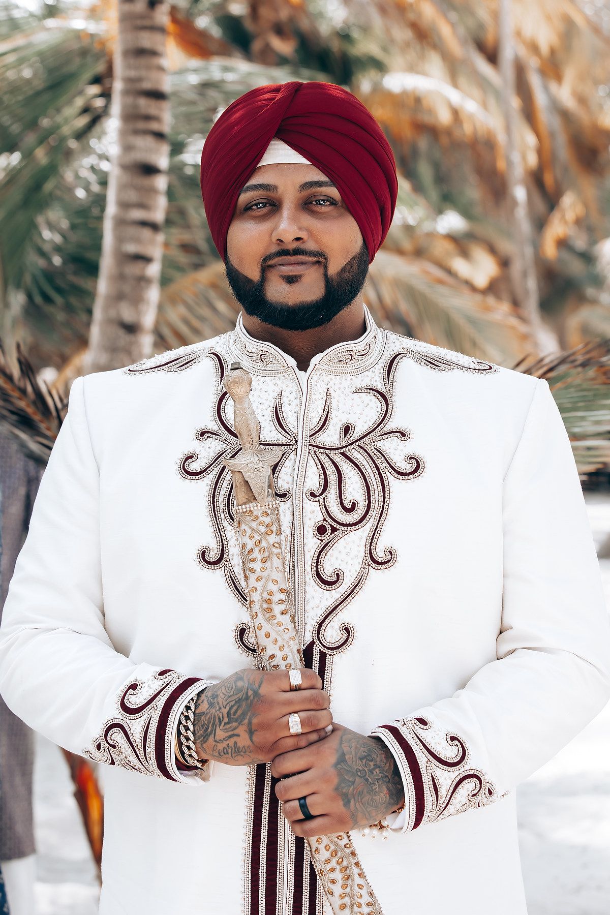 Traditional Sikh wedding attire featuring white sherwani with intricate embroidery details.