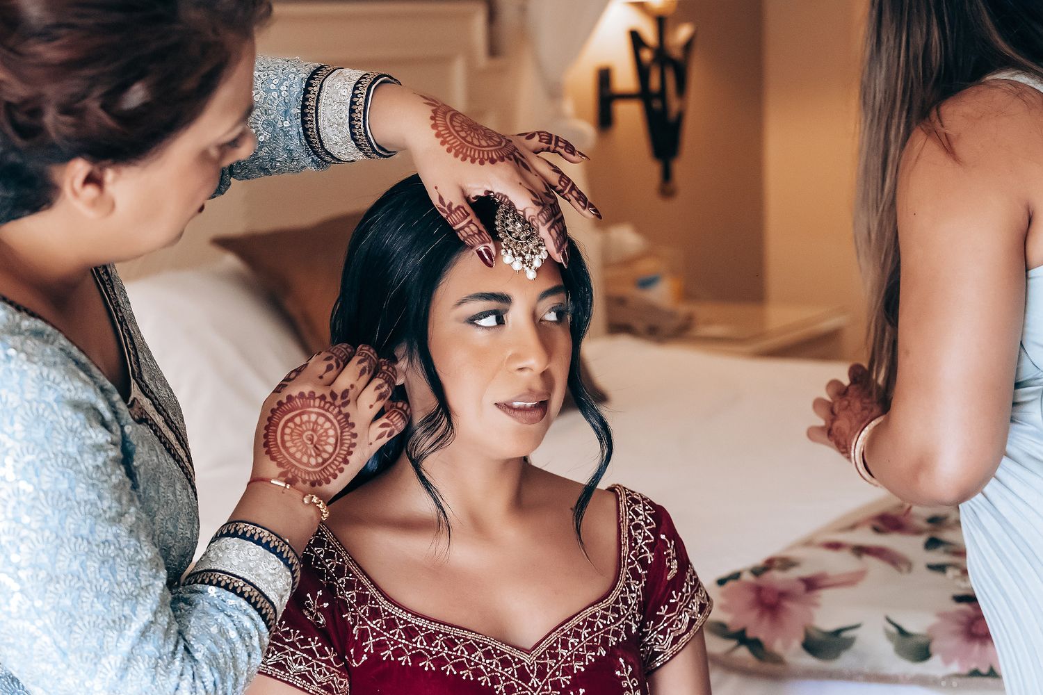 Intricate henna designs being applied during traditional Indian wedding preparations.