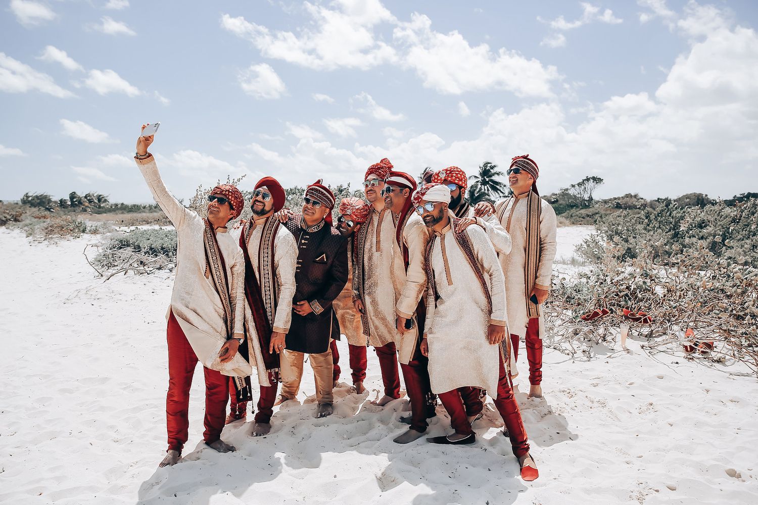 Wedding party throws snow in the air during winter celebration on snowy ground.