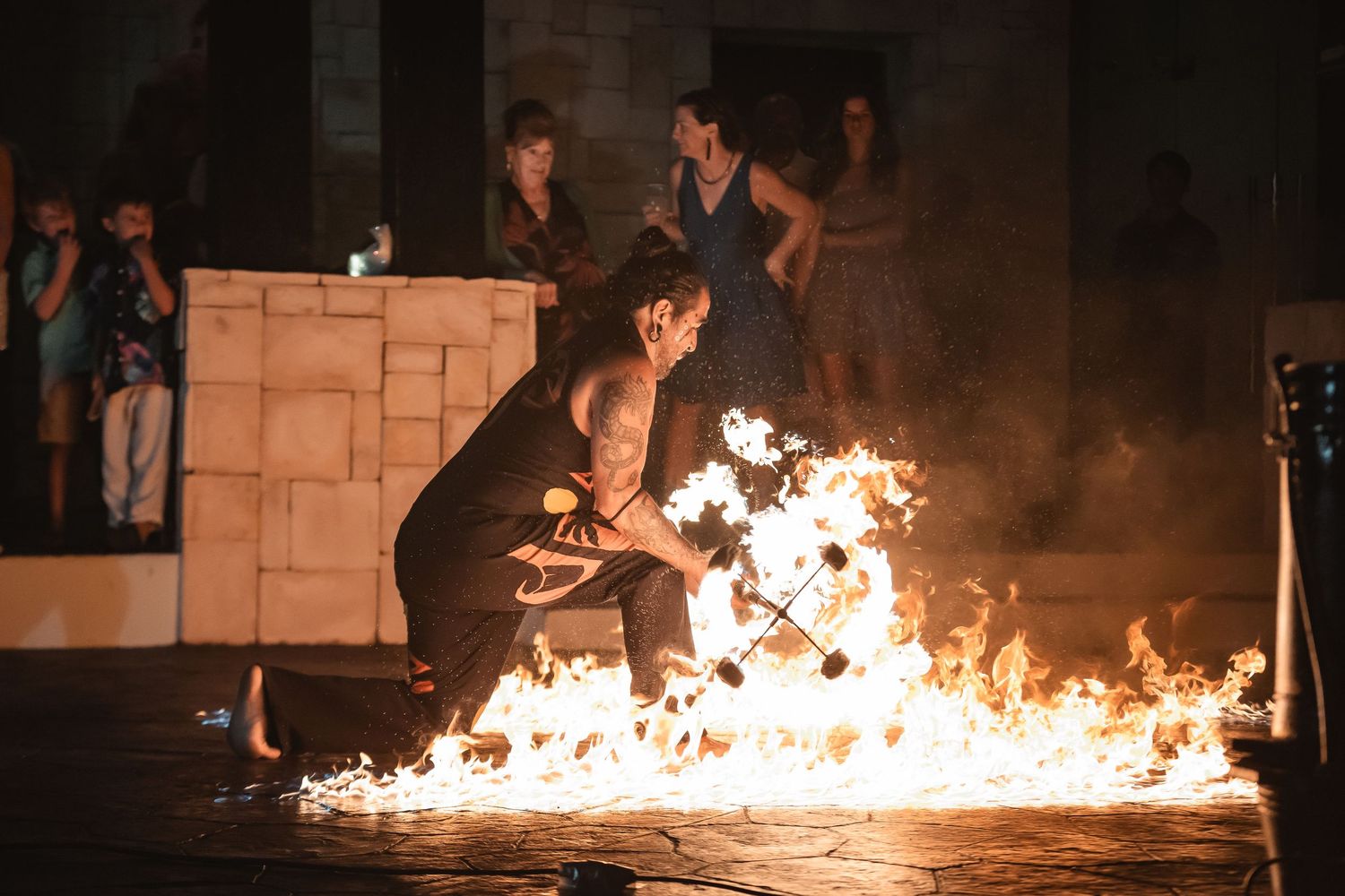 A dramatic fire performance creates a line of flames in the darkness.
